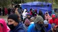Migrantes venezolanos se forman para recibir alimentos y bebidas calientes en un campamento improvisado en la ciudad norteña de Matamoros, México, el viernes 23 de diciembre de 2022.&nbsp;