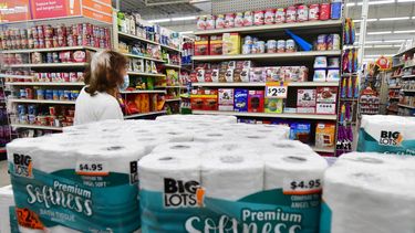 Una señora observa los precios en un supermercado.