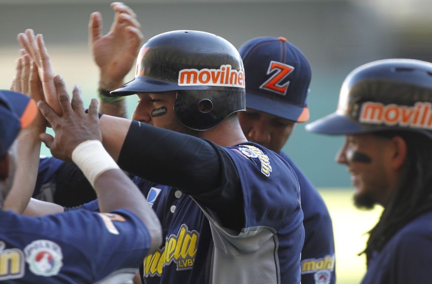 Jesús Flores es recibido por sus compañeros luego de conectar un cuadrangular en la segunda entrada