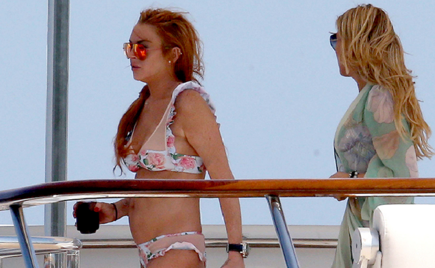 Lindsay Lohan y una amiga durante su paseo en yate. (PEOPLE).