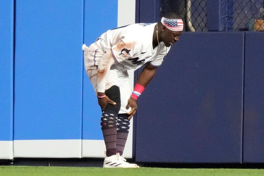 El jardinero central de los Marlins de Miami, Jonathan Davis, se toca la rodilla luego de sufrir una lesión en el quinto inning del juego del 4 de julio de 2023.