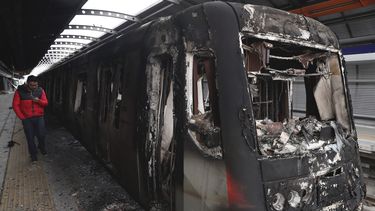 Vagones del metro quemados por manifestantes est&aacute;n detenidos en la estaci&oacute;n Elisa Correa en Santiago de Chile el domingo 20 de octubre de 2019.