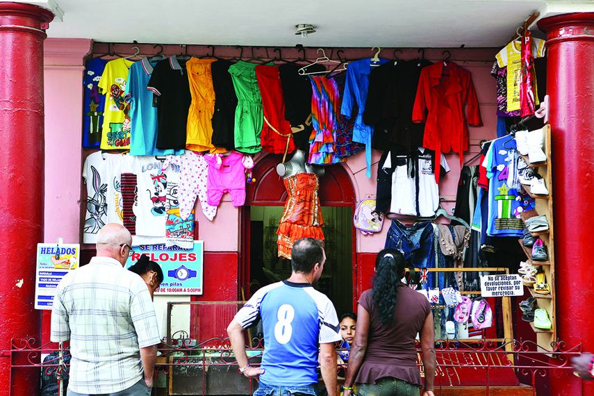 Varias personas compran ropa en una pequeña tienda privada en La Habana. (EFE)