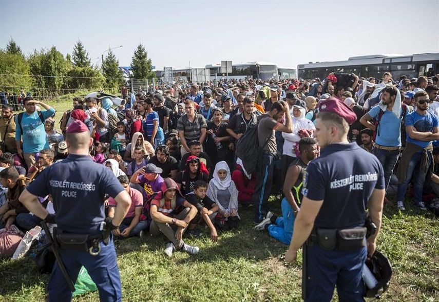 La policía vigila a un grupo de inmigrantes en la frontera entre Hungría y Croacia en la localidad de Beremend. (EFE)