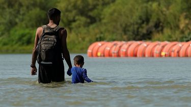 Migrantes cerca de la barrera flotante en el río Bravo cerca de Eagle Pass, Texas, el 1 de agosto de 2023.&nbsp;