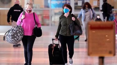 Dos mujeres con mascarillas caminan por un pasillo del aeropuerto Love Field de Dallas, el martes 2 de marzo de 2021.&nbsp;