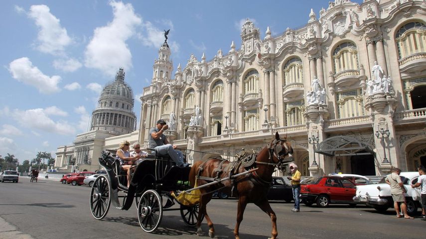 Una pareja de turistas pasea en un coche de caballos por La Habana.