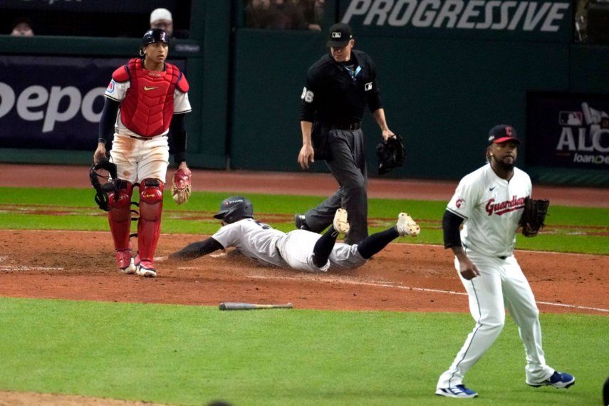 Jon Berti, de los Yankees de Nueva York, anota entre el cátcher Bo Naylor y el pitcher dominicano Emmanuel Clase, de los Guardianes de Cleveland, en el cuarto juego de la Serie de Campeonato de la Liga Americana, el viernes 18 de octubre de 2024&nbsp;