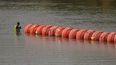 Un trabajador inspecciona las boyas utilizadas como barrera a lo largo del río Bravo _Rio Grande en Estados Unidos_ el lunes 21 de agosto de 2023, en Eagle Pass, Texas.&nbsp;