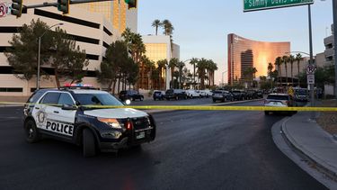 Una patrulla policial detrás de la cinta amarilla custodia el área del crimen.&nbsp;