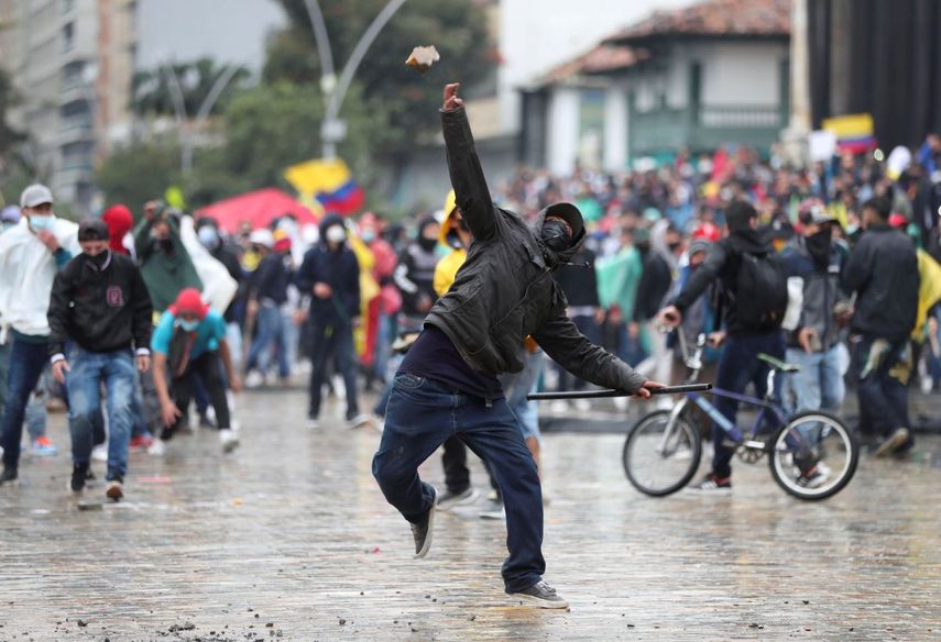 Un manifestante lanza una piedra a la policía en Bogotá.