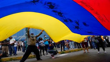 Simpatizantes de Tomás Guanipa, candidato a la alcaldía de la Mesa de la Unidad Democrática (MUD) del municipio Libertador, ondean una bandera venezolana en un mitin el primer día de la campaña de 2021.