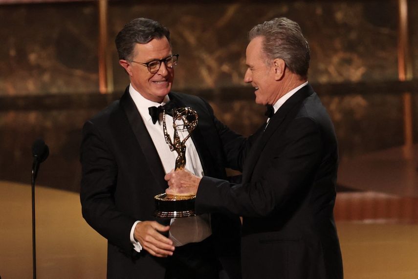 Stephen Colbert acepta el premio a la mejor serie de entrevistas por The Late Show with Stephen Colbert de manos del actor estadounidense Bryan Cranston (derecha) durante la 77.ª edición de los Premios Emmy