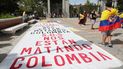 Una pancarta donde se lee Nos están matando, en una manifestación contra la llegada del presidente de Colombia a Madrid, en la Puerta de Alcalá, a 12 de septiembre de 2021.