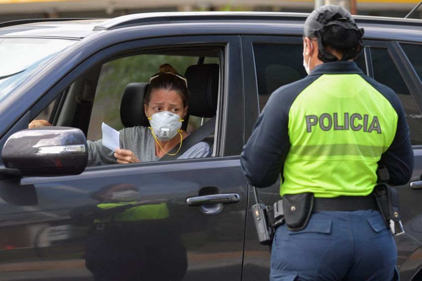 Una oficial de policía le pide a la conductora un permiso especial que le permite salir de su casa, en la ciudad de Panamá el 25 de marzo de 2020.&nbsp;Panamá se encuentra en cuarentena desde el 24 de marzo por&nbsp;causa de la pandemia mundial del nuevo coronavirus, COVID-19.