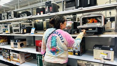 Una mujer revisa un minihorno en&nbsp; una tienda en Estados Unidos.