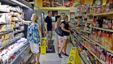 Varias personas buscan productos en un mercado en Miami.