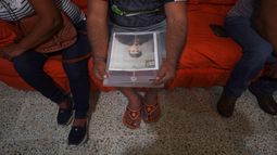 Salvador Morales sostiene una carpeta con la fotografía de su hijo desaparecido, Alan Morales, durante una reunión de la Red Milynali, un colectivo de familias que asisten en la búsqueda de familiares desaparecidos.
