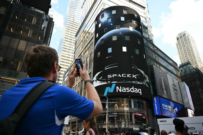 Un hombre tira foto a la gigantesca pantalla de Nasdaq en el Time Square de Nueva York.