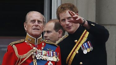 En esta foto del 14 de junio de 2014, el príncipe Harry de Inglaterra habla con su abuelo, el príncipe Felipe, en el balcón del Palacio de Buckingham durante el desfile del Trooping The Colour en Londres.&nbsp; 