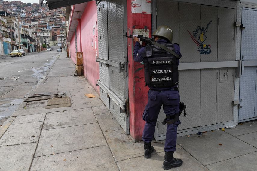 Un miembro de la Policía Nacional Bolivariana apunta a un posible objetivo luego de enfrentamientos con presuntos miembros de una banda criminal en el barrio Cota 905, en Caracas, el 9 de julio de 2021&nbsp;