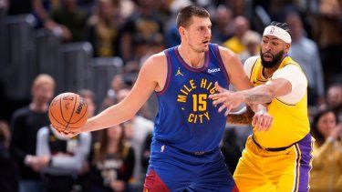 El serbio Nikola Jokic, pívot de los Nuggets de Denver, busca enviar un pase frente a Anthony Davis, alero de los Lakers de Los Ángeles, en el partido inaugural de la campaña de la NBA, el martes 24 de octubre de 2023&nbsp;