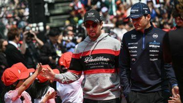 El piloto mexicano de Cadillac, Sergio Pérez (izq), y el piloto español de Williams, Carlos Sainz, llegan al desfile de conductores previo al Gran Premio de Japón de Fórmula 1 en el circuito de Suzuka.