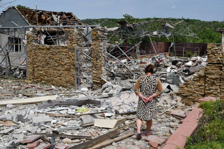 Una mujer camina junto a una vivienda destruida durante un ataque con misiles, el miércoles 1 de junio de 2022, en Sloviansk, Ucrania.