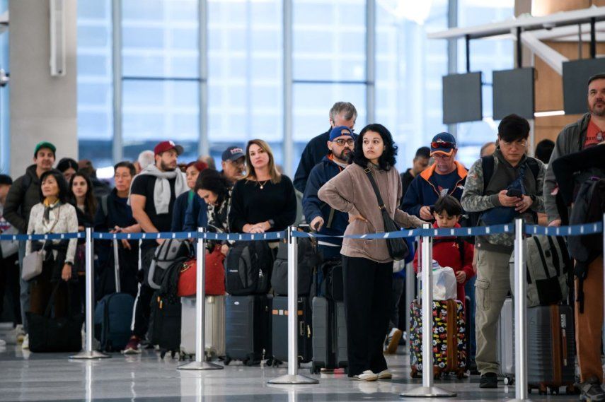 La gente espera en la fila del control de seguridad en el Aeropuerto.