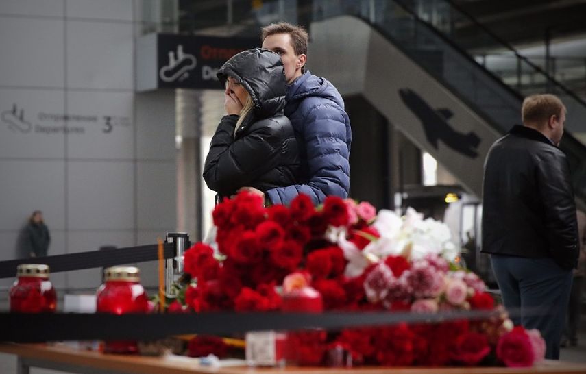 Familiares de las víctimas del avión siniestrado en Egipto frente a velas y ofrendas en memora de los fallecidos en el aeropuerto de Pulkovo, en St. Petersburg, Russia (EFE)
