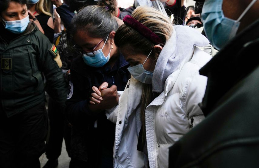 La expresidenta interina de Bolivia, Jeanine Áñez, recibe ayuda cuando es devuelta a la cárcel de mujeres de Miraflores, luego de ser tratada en una clínica privada en La Paz, Bolivia, el martes 24 de agosto de 2021