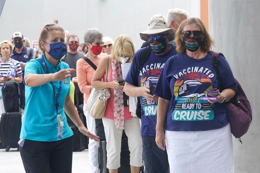 Orchid Klaric, a la izquierda, ayuda a Brenda y Kurd Duncan, de Denver, para que puedan registrarse como pasajeros en un crucero en Fort Lauderdale, Florida.