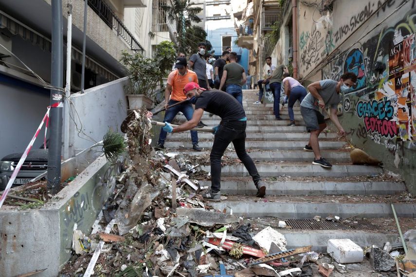 Personas remueven escombros de una calle tras la explosi&oacute;n en Beirut, L&iacute;bano, mi&eacute;rcoles 5 de agosto de 2020.&nbsp;