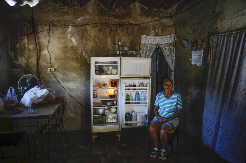 Rosa López posa junto a su refrigerador antes de preparar una comida para sus nietos en medio de una escasez de gas en Mariel, Cuba.