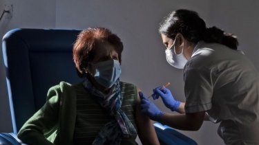 Enfermera suministra vacuna a persona de la tercera edad.