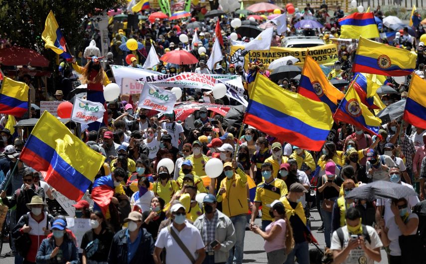 La gente sostiene banderas de Colombia mientras participan en una nueva protesta contra el gobierno del presidente colombiano Iván Duque, en Bogotá el 19 de mayo de 2021. &nbsp;