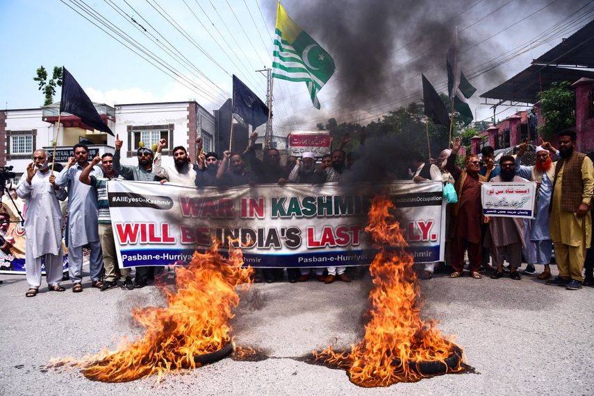 Activistas y miembros de Pasban-e-Hurriyat, una organización de refugiados cachemires, gritan consignas junto a neumáticos en llamas durante una protesta contra la India en Muzaffarabad, capital de la Cachemira administrada por Pakistán, el 5 de mayo de 2025.&nbsp;