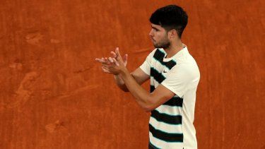 El español Carlos Alcaraz aplaude al italiano Lorenzo Musetti después de que este último se retirara debido a una lesión en su partido de semifinales individuales masculino en el día 13 del torneo de tenis Abierto de Francia, en la cancha Philippe-Chatrier en el Complejo Roland Garros en París, el 6 de junio de 2025.&nbsp;