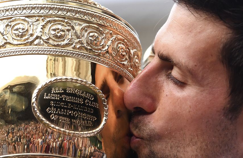 En esta foto del 14 de julio de 2019, Novak Djokovic besa el trofeo de campe&oacute;n tras vencer a Roger Federer en la final de Wimbledon.