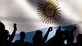 Con una bandera argentina de fondo en una pantalla, simpatizantes de Javier Milei, graban con sus teléfonos mientras habla en un mitin de campaña con trabajadores sindicales en Buenos Aires el 22 de septiembre de 2023.
