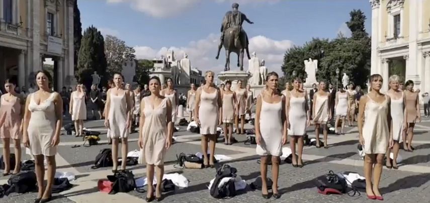 En esta imagen de un video, exempleados de la difunta aerolínea Alitalia protestan en lo alto de la colina Capitolina en Roma, miércoles 20 de octubre de 2021. Decenas de ex asistentes de vuelo de Alitalia, que dejó de existir este mes, se quitaron sus uniformes y permanecieron en ropa interior en una protesta en el centro de Roma. (Federico Mariani/USB video via AP)