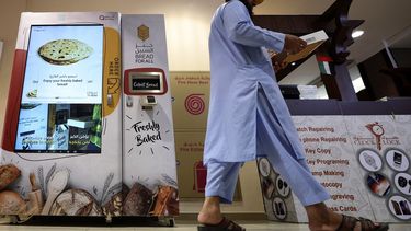 Un hombre camina después de recolectar artículos de una máquina expendedora que reparte pan gratis, en Dubái, el 22 de septiembre de 2022.&nbsp;