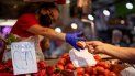 Un cliente paga por verduras en el Mercado de Maravillas de Madrid, el jueves 12 de mayo de 2022.