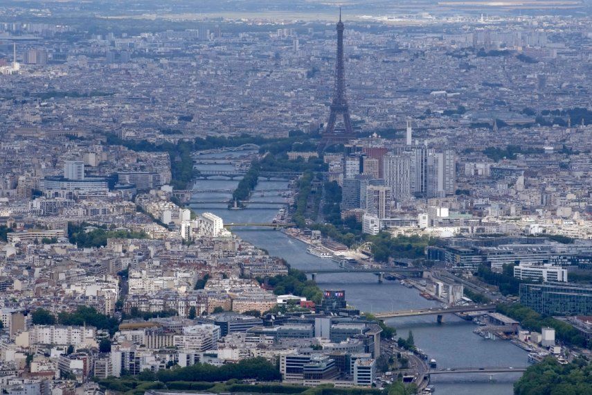 En foto del 11 de julio del 2023, toma aérea del Río Sena a través de París con la Torre Eiffel al centro.