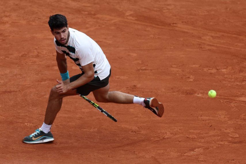 El español Carlos Alcaraz devuelve un golpe de derecha hacia atrás al italiano Giulio Zeppieri durante su partido individual masculino en el segundo día del torneo de tenis Abierto de Francia en la cancha Suzanne-Lenglen en el Complejo Roland-Garros en París el 26 de mayo de 2025.  El español Carlos Alcaraz devuelve un golpe de derecha hacia atrás al italiano Giulio Zeppieri durante su partido individual masculino en el segundo día del torneo de tenis Abierto de Francia en la cancha Suzanne-Lenglen en el Complejo Roland-Garros en París el 26 de mayo de 2025.