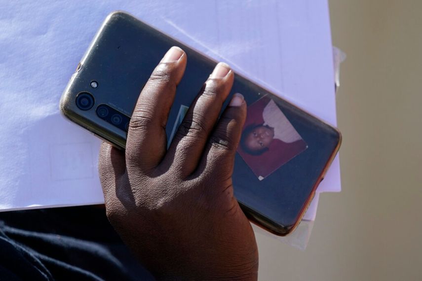 Una de las migrantes sostiene su celular, con una fotografía en la funda, a su llegada a un centro de ayuda humanitaria tras ser liberado por la Patrulla Fronteriza de Estados Unidos tras cruzar el río Bravo y entregarse a las autoridades para solicitar asilo, el 22 de septiembre de 2021, en Del Rio, Texas.
