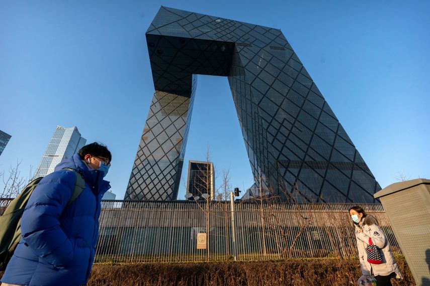Fotografía de archivo del 4 de febrero de 2021 de personas caminando frente a las oficinas generales de la televisora estatal china CCTV y de su brazo para el extranjero CGTN, en Beijing.&nbsp;