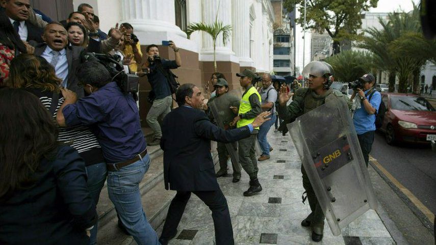 Legisladores de la Asamblea Nacional de Venezuela forcejean con miembros de la Guardia Nacional Bolivariana en el exterior de la sede del organismo, mientras los diputados intentar dar acceso a periodistas, en Caracas, Venezuela