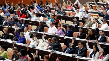 Diputados cubanos participan en una votación durante la sesión plenaria del Parlamento unicameral de la isla.