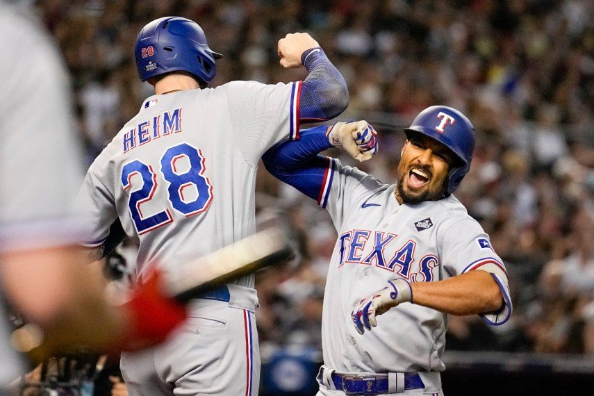 Marcus Semien (derecha) festeja su jonrón de tres carreras junto a Jonah Heim, su compañero en los Rangers de Texas, en el cuarto juego de la Serie Mundial ante los Diamondbacks de Arizona, el martes 31 de octubre de 2023.